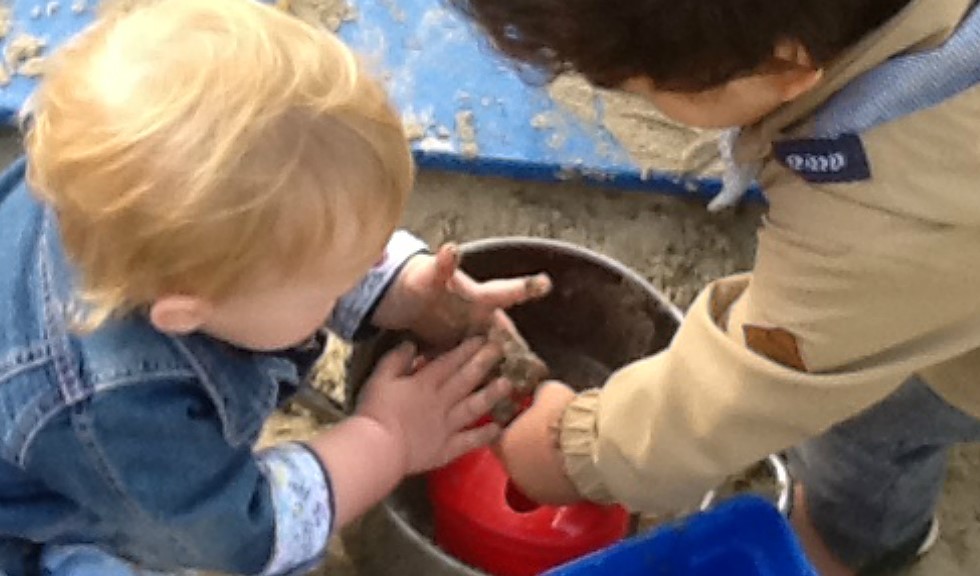 Buiten spelen met zand, bij KDV De Piramide.
